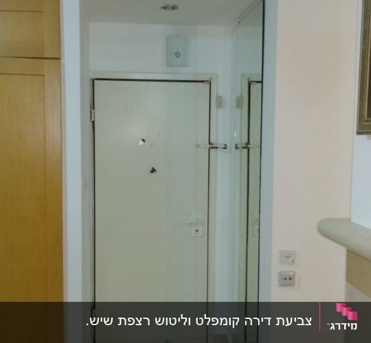 דלת לבנה עם קיר צבוע בלבן ומראה